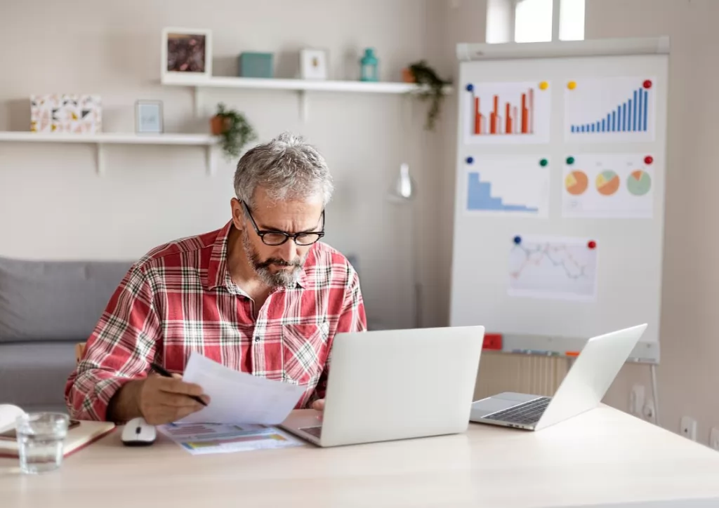 Mężczyzna siedzący przed laptopem i prowadzący własną firmę w Niemczech