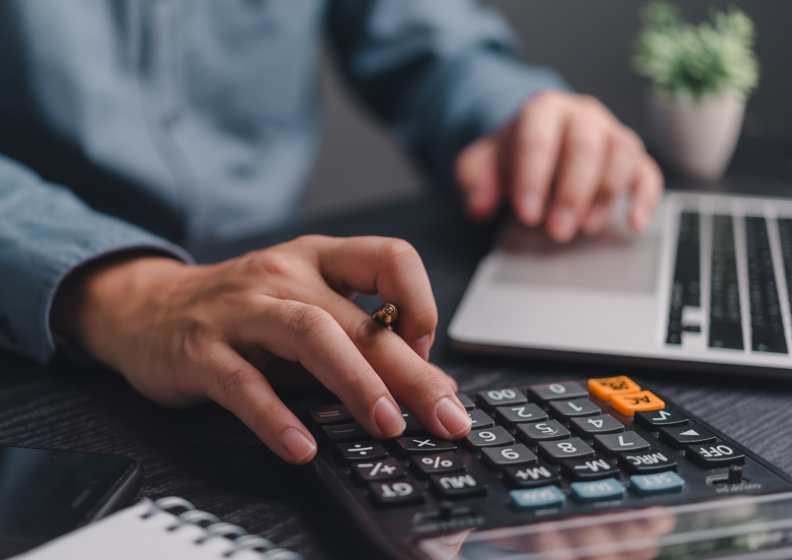 Księgowość dla kleingewerbe - Księgowy korzysta z kalkulatora podczas sprawdzania dokumentacji finansowej przy laptopie
